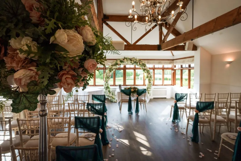 Beautifully decorated wedding ceremony venue in Shropshire with floral-lined aisle at The Shropshire’s countryside wedding venue