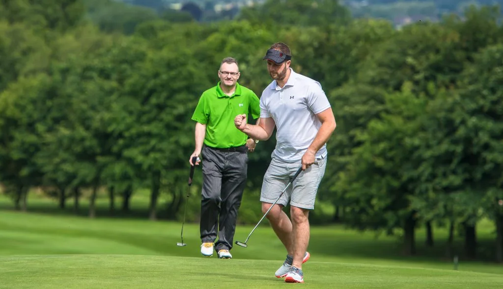 Golfer fist pumping after sinking a putt on the 18 hole golf course in Telford at The Shropshire Golf Club during a golf day
